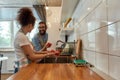 Happy young couple washing vegetables, tomatoes in the kitchen while preparing ingredients for dinner. Cooking at home Royalty Free Stock Photo