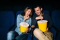 Happy young couple watching comedy movie in cinema, smiling Royalty Free Stock Photo