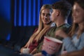 Happy young couple watching film in the cinema, talking. Royalty Free Stock Photo