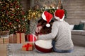 Happy young couple wearing Santa hats in room decorated for Christmas Royalty Free Stock Photo