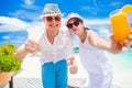 Happy young couple in white clothes having fun with delicious cocktails by the beach Royalty Free Stock Photo