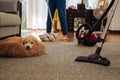 Happy young couple of woman cleaning carpet with vacuum cleaner machine and man mopping the floor at home Royalty Free Stock Photo