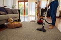 Happy young couple of woman cleaning carpet with vacuum cleaner machine and man mopping the floor at home Royalty Free Stock Photo