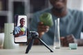 Happy young craftsman with handmade vase on screen of smartphone