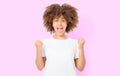 Happy young dark skin afro woman on pink background in tshirt clothes. Copy space. Mock up. White template blank t shirt