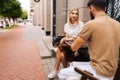 Happy young dating couple having coffee together and enjoying life sitting at table in street cafe on summer day. View Royalty Free Stock Photo