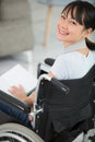 happy young disabled woman reading in wheelchair Royalty Free Stock Photo