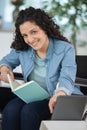 happy young disabled woman in wheelchair with book Royalty Free Stock Photo