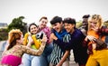 Happy young diverse friends having fun with old vintage video camera outdoor