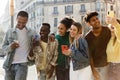 Happy young diverse group of people laughing together using mobile phone Royalty Free Stock Photo