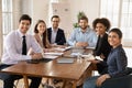 Happy young diverse team of professionals posing at office table Royalty Free Stock Photo