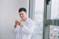 Happy young doctor holding cell phone Royalty Free Stock Photo