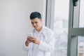 Happy young doctor holding cell phone Royalty Free Stock Photo