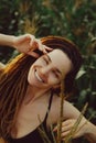 Happy young dredlocks girl in cornfield