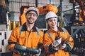 happy young engineer working together service team with robot welding in automation factory. Man and woman smiling worker in Royalty Free Stock Photo