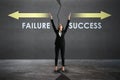 Happy young european businesswoman choosing between failure and success arrows sketch on concrete background. Direction, growth, Royalty Free Stock Photo