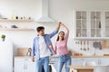 Happy young european couple have fun in modern kitchen interior. Loving man and woman dancing Royalty Free Stock Photo