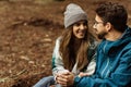 Happy young european man and female tourists in jackets rest in autumn forest, enjoy cold season outdoor Royalty Free Stock Photo