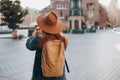 Happy young European tourist with backpack in hat makes photo or video on smartphone on Market Square in Krakow Royalty Free Stock Photo