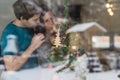 Happy young family with baby behind decorated Christmas tree at Royalty Free Stock Photo