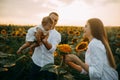 Happy family with baby has a fun and plays in the sunflower field Royalty Free Stock Photo