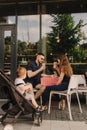 Happy young family with baby son eating lunch together at restaurant and having fun. Soft focus blurred and noise effect Royalty Free Stock Photo