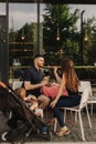 Happy young family with baby son eating lunch together at restaurant and having fun. Soft focus blurred and noise effect Royalty Free Stock Photo