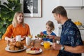 happy family with child eating healthy breakfast by the table at home kitchen in the morning Royalty Free Stock Photo