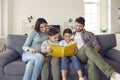 Happy family with children enjoying free time at home and reading a book together Royalty Free Stock Photo