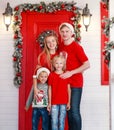 Happy young family with children joyfully celebrate new year together at house on veranda, in Christmas decorations