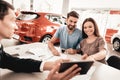 Young Family Are Choosing A New Car In Showroom. Royalty Free Stock Photo