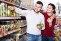 Happy young family choosing purchasing canned food for week at s Royalty Free Stock Photo