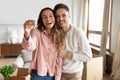 Happy couple holding key to new home on moving day Royalty Free Stock Photo