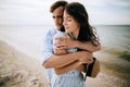 Happy young family couple hugging and kissing on the sea beach. Honeymoon and love concept. Summer vacation Royalty Free Stock Photo