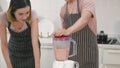 Couple husband and wife making fresh smoothie in kitchen together at home Royalty Free Stock Photo