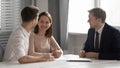 Happy young family couple making decision meeting bank manager insurer