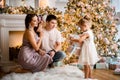 Happy young family couple with little child open gifts near christmas tree Royalty Free Stock Photo