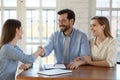Happy young family couple shaking hands with real estate agent. Royalty Free Stock Photo