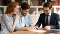 Happy young family couple signing agreement with lawyer. Royalty Free Stock Photo