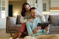 Happy young family couple using mobile tablet at home together Royalty Free Stock Photo