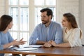 Happy young family couple visiting female real estate agent. Royalty Free Stock Photo