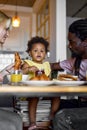 Happy young family with daughter having breakfast together at table in modern kitchen, love Royalty Free Stock Photo