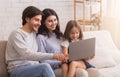 Happy young family with daughter using laptop together at home Royalty Free Stock Photo