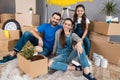 Happy young family dismantles cardboard boxes and makes home improvement.