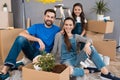 Happy young family dismantles cardboard boxes and makes repairs in new house.
