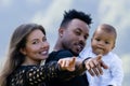 Happy young family, diverse parents have fun with baby in summer yard. Overjoyed multiracial family with small baby Royalty Free Stock Photo