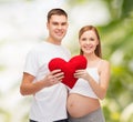 Happy young family expecting child with big heart Royalty Free Stock Photo