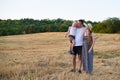 Happy young family. A father with a little son in her arms and a pregnant mother. Beveled wheat field on the background. Sunset Royalty Free Stock Photo