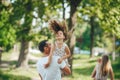 Happy young family father, mother and children having fun outdoors, playing together in summer park, countryside Royalty Free Stock Photo