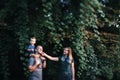 Happy young family father, mother and little son hugging and touching outdoors, playing together in summer park Royalty Free Stock Photo